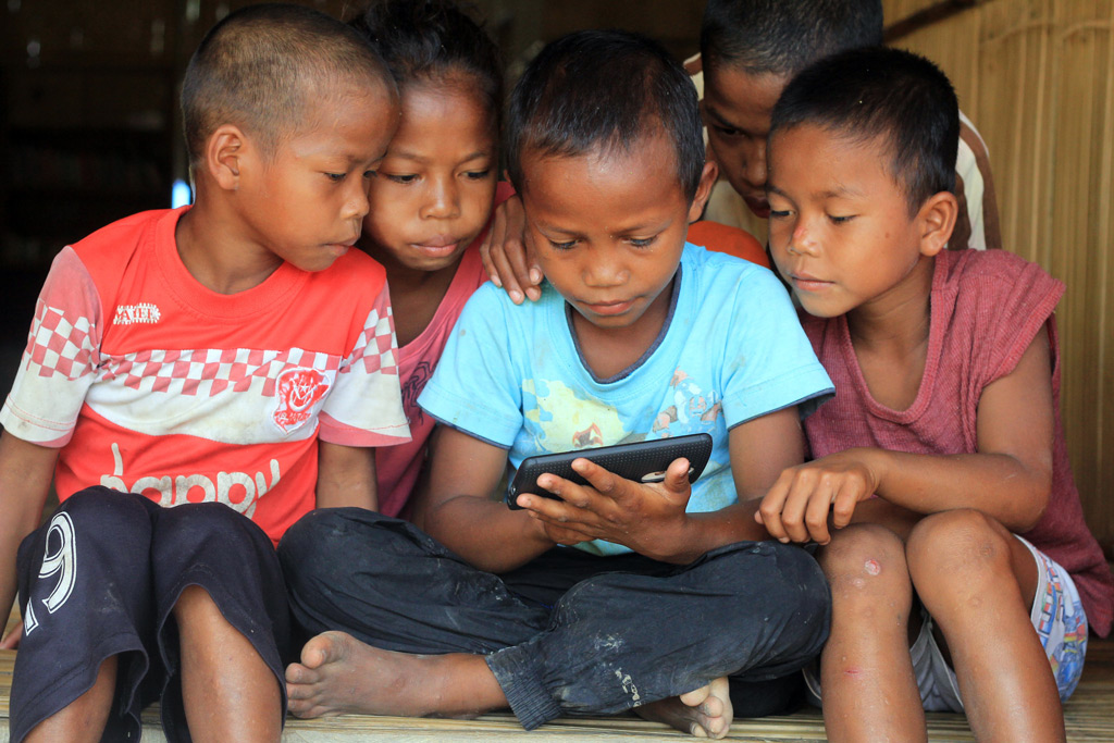 Фото: Дети смотрят что-то с мобильного телефона