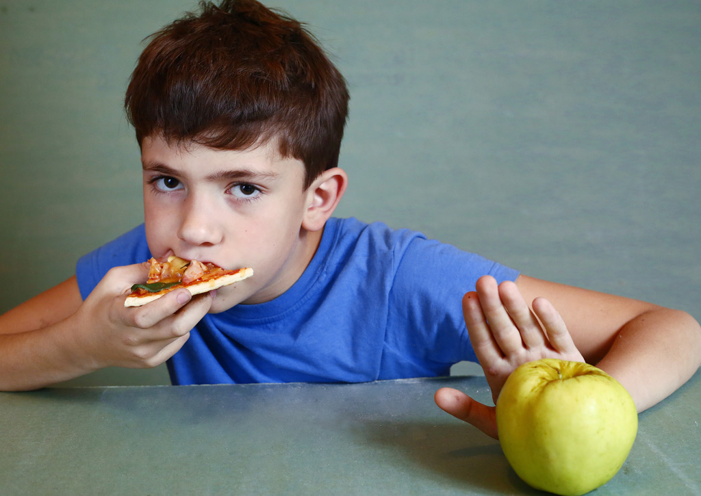 Фото: Мальчик ест пиццу